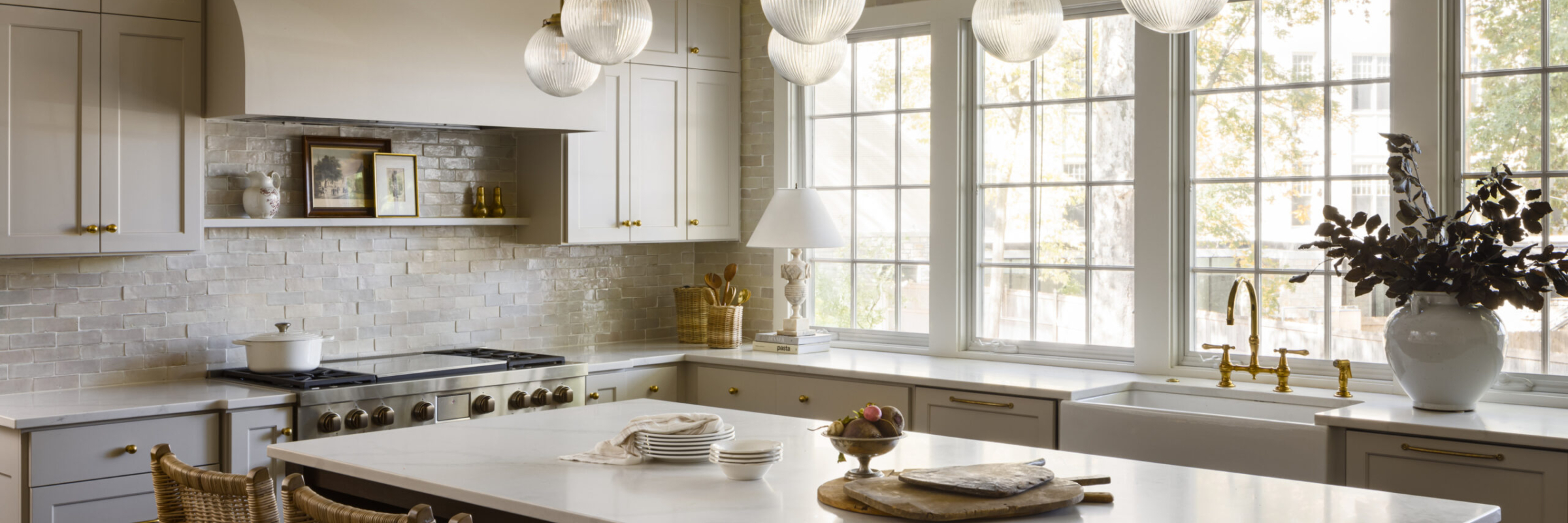 Large kitchen island with brass chandelier in kitchen remodel