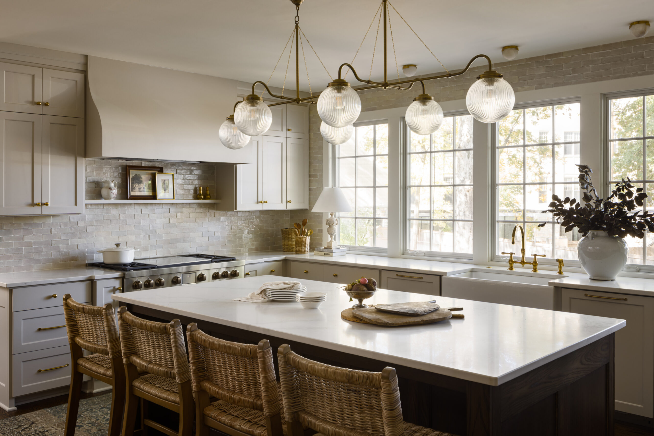 Large kitchen island with brass chandelier in kitchen remodel