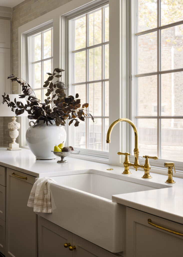 Traditional style kitchen remodel with wall of windows and brass faucet